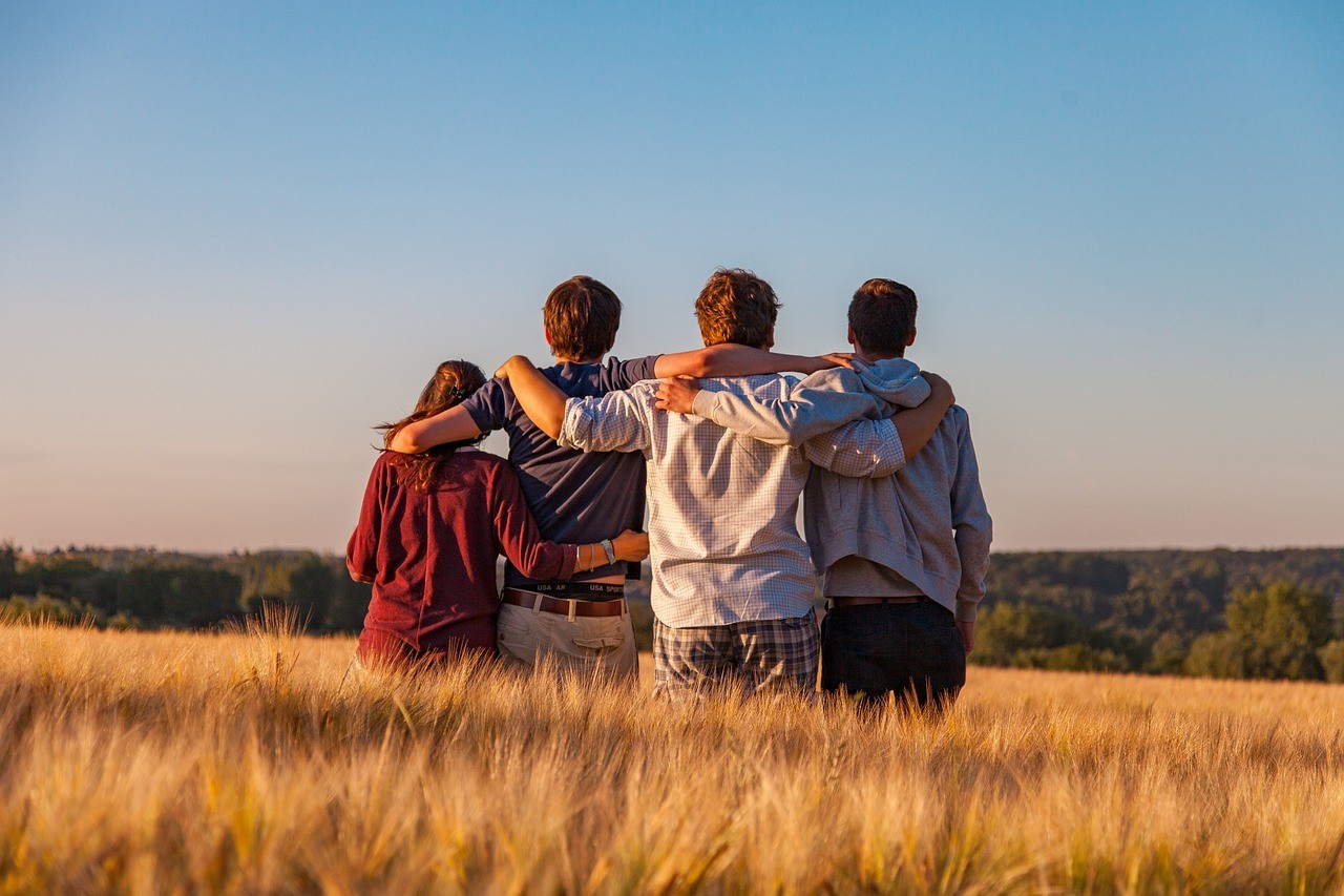 Amigos se abraçando no campo ensolarado